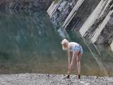 Busty blonde displays her figure near the lake